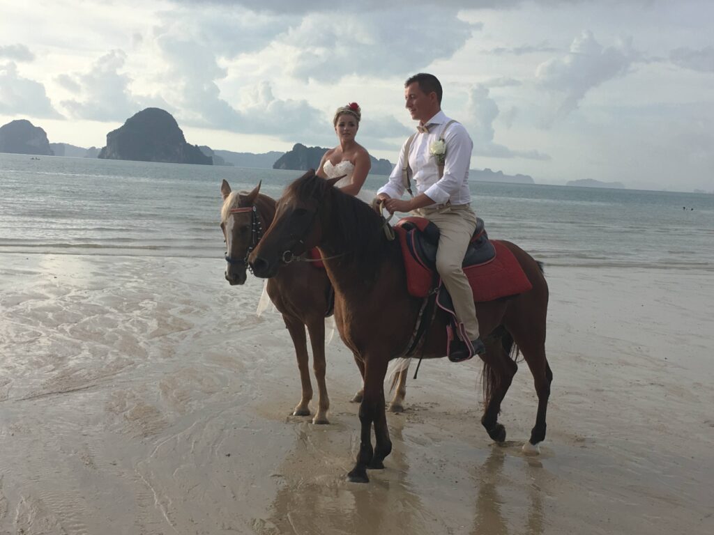 Sposi a cavallo sulla spiaggia in Thailandia